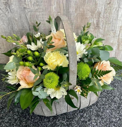 Peach & Cream - A charming basket arrangement in soft peach, cream and fresh green tones, beautifully finished with lush foliage for a natural, elegant look.